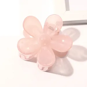 Close-up of a pink floral hair claw clip made of semi-transparent resin with metal spring