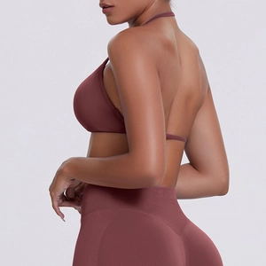 Detail of cross-back seamless rust red sports bra and high waist yoga leggings set