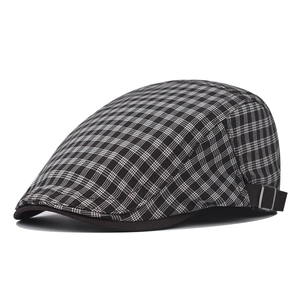 Detail of British plaid beret featuring classic grey check pattern and adjustable metal buckle