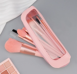 Detail of pink makeup brush set with soft synthetic bristles and transparent travel pouch