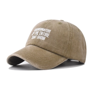 Detail of washed khaki cotton cap showing vintage slogan print and six-panel construction
