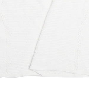 Gros plan sur la texture du tricot blanc avec motif côtelé et détails de couture décorative