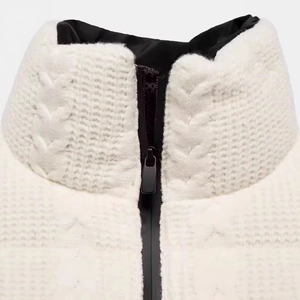White knit ski jacket with high collar and contrasting black zipper detail