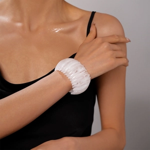 Vue détaillée d'un bracelet large en acrylique blanc au design géométrique segmenté