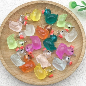 Colorful resin duck charms for DIY jewelry making displayed on a small wooden tray