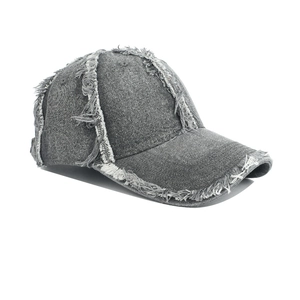 Close-up of gray washed denim baseball cap featuring distressed frayed edge details