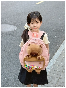 Pink toddler backpack featuring a plush capybara toy and colorful decorative beads
