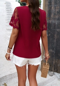 Detail view of the lace patchwork sleeves and back design on this red short sleeve top