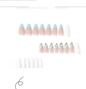 Macro detail of almond press-on nails featuring blue rhinestones and white flower art