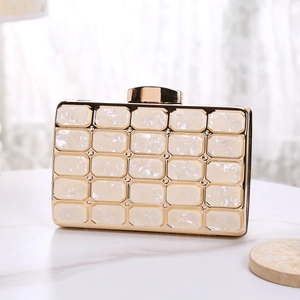 Detail view of acrylic evening clutch with marble panels and gold metal frame finish