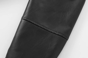 Close-up of black faux leather bomber jacket showing premium texture and seam stitching