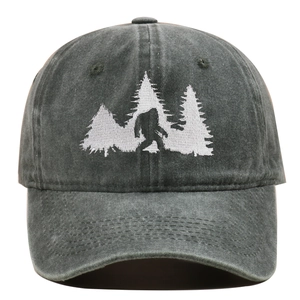 Close-up of Bigfoot silhouette embroidery on washed dark green cotton baseball cap
