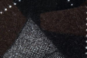 Macro shot of high-quality dark chocolate knit fabric showing detailed wool textures