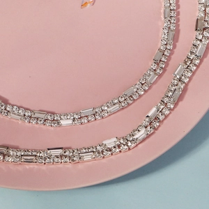 Detailed macro view of silver bridal jewelry featuring rectangular and round rhinestones