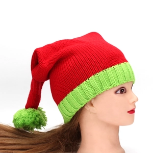 Détail du bonnet de Noël tricoté rouge et vert avec texture épaisse et pompon