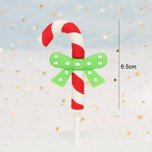 Macro view of 6.5cm Christmas candy cane cake topper with green polka dot bow