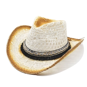 Détail d'un chapeau de cowboy en paille avec ruban bohème, sequins dorés et franges noires