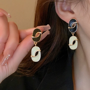 Detail of vintage oval black and white enamel earrings with luxury geometric design