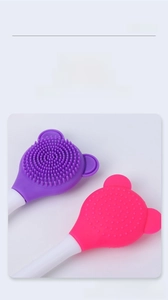 Detailed view of dual-sided silicone face mask brush with cute bear shaped head in pink and purple