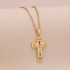 Detailed macro view of gold cross pendant with colorful zircon stones on thin chain