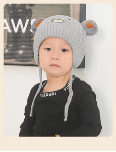 Détail du bonnet tricoté pour enfant avec oreilles d'ours et broderie grise douce