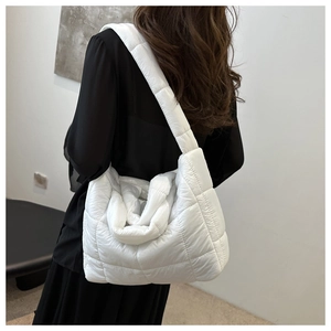 Back view of a model wearing a white quilted puffer tote bag with a minimalist design