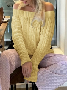 Close-up of yellow off-the-shoulder cable knit sweater with detailed texture and pattern