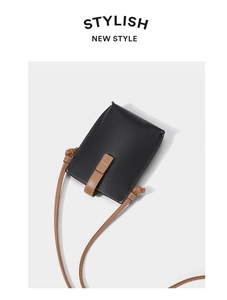 Detail of genuine leather phone bag showing pebbled texture and brown knotted shoulder strap