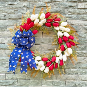 Patriotischer Weihnachtskranz mit Tulpen und blauer Sternschleife an der Steinwand