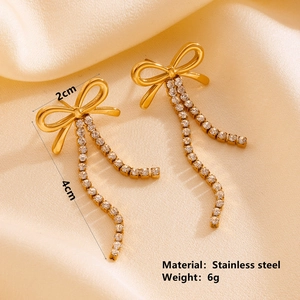 Detail view of gold stainless steel bow earrings with rhinestone tassels and measurements
