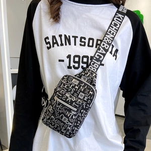 Detail of black crossbody chest bag with white letter print and wide logo strap