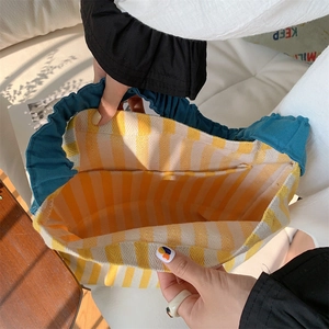 Close-up of the spacious interior with blue ruffled edge and yellow striped lining