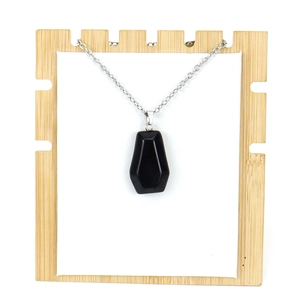Macro view of a black obsidian coffin pendant with a polished silver metal chain
