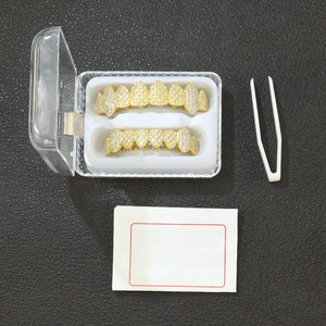 Close-up of golden hip-hop grillz set with cubic zirconia in a clear storage case