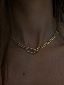 Close-up of golden chunky chain choker necklace with a sparkling pave crystal oval clasp