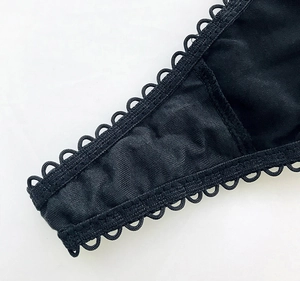 Dettaglio del bordo in pizzo nero che mostra il tessuto a maglia e le cuciture fini