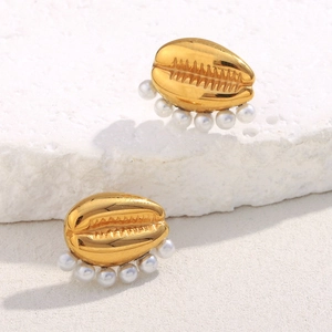 Detail of 18K gold-plated shell earrings with white pearls on white stone