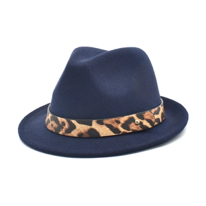 Detailed close-up of navy wool fedora hat featuring a leopard print leather belt buckle