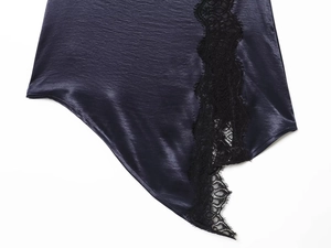 Close-up of deep blue satin fabric and black lace patchwork on a mini dress
