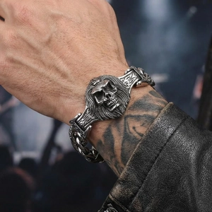 Close-up of vintage punk skull charm on heavy steel Cuban chain bracelet for men