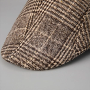 Macro shot of brown houndstooth wool fabric texture and fine stitching on the flat cap