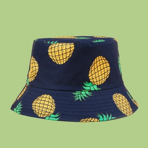 Close-up of fabric texture and vibrant pineapple print on navy blue bucket hat