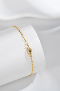 Macro detail of gold S925 sterling silver evil eye bracelet with blue and white stones