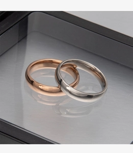 Close-up of 4mm rose gold and silver stainless steel rings in a black display case