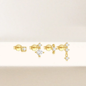 Detailed macro view of four S925 sterling silver gold stud earrings with cubic zirconia