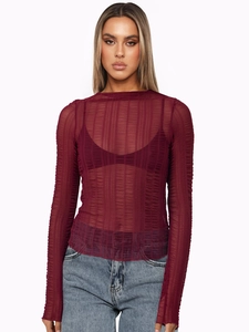 Close-up of wine red sheer mesh long sleeve top with textured vertical ribbing fabric