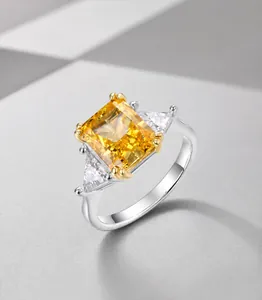 Detalle del anillo de diamante amarillo talla esmeralda con piedras laterales