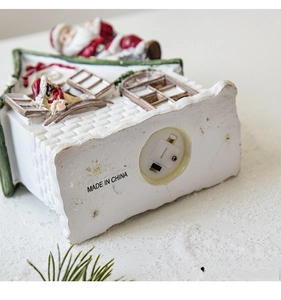 Detail view of the Christmas house base showing the LR44 battery compartment and power switch
