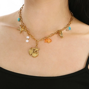 Detail of bohemian gold double-layer necklace with sea shells and turquoise beads on neck