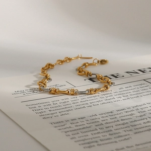 Dettaglio del bracciale a maglie bicolore oro e argento con chiusura a moschettone
